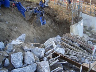 Excavating trench on slope for vegetated riprap application 
