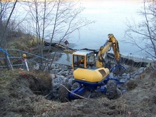 Spyder hoe placing rock 