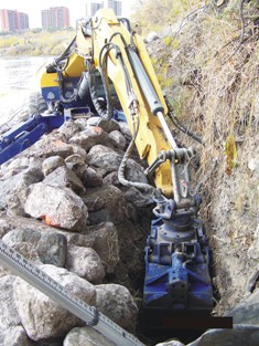 Spyder hoe excavating trench on slope to installed vegetated riprap, October 2007 